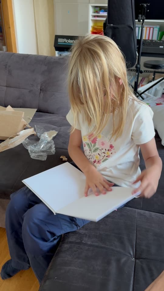A little reader unboxes and opens her personalized Stattner storybook at home.