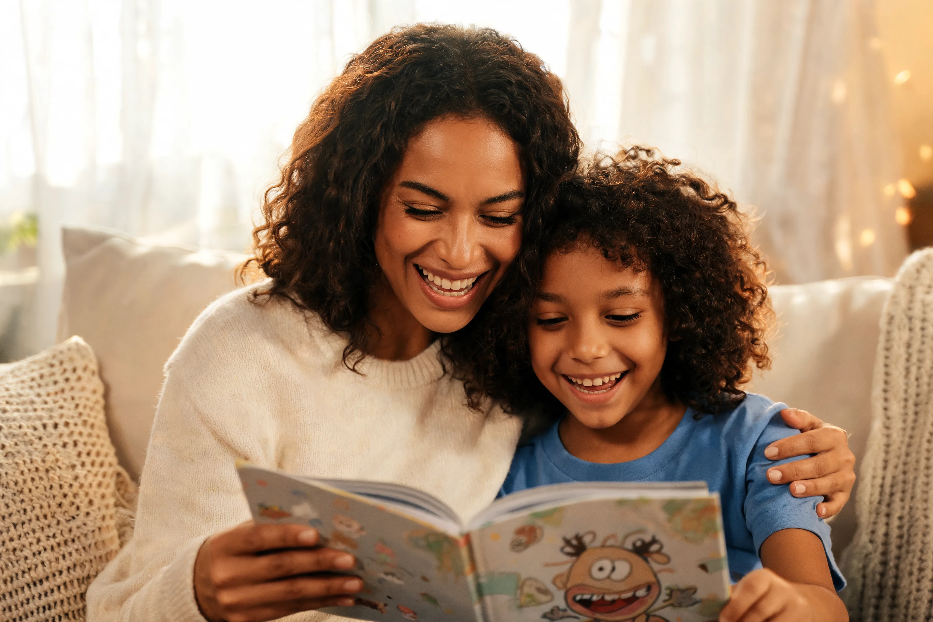 Parent and child laughing over a book, suggesting ways to make reading fun for reluctant readers